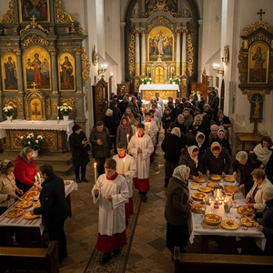 Candlemas, celebrated on February 2nd, marks the presentation of Jesus at the temple in Christian tradition. The image should depict a candlelight procession with people holding lit candles, symbolizing the religious significance of the day. In addition, include elements of traditional customs, such as the preparation of pancakes (associated with the day in various cultures) and rural or folk practices like "groundhog day" traditions. The scene can be set in a church or a festive setting where the spiritual and popular aspects of Candlemas converge, showcasing both the sacred and the cultural side of this holiday.